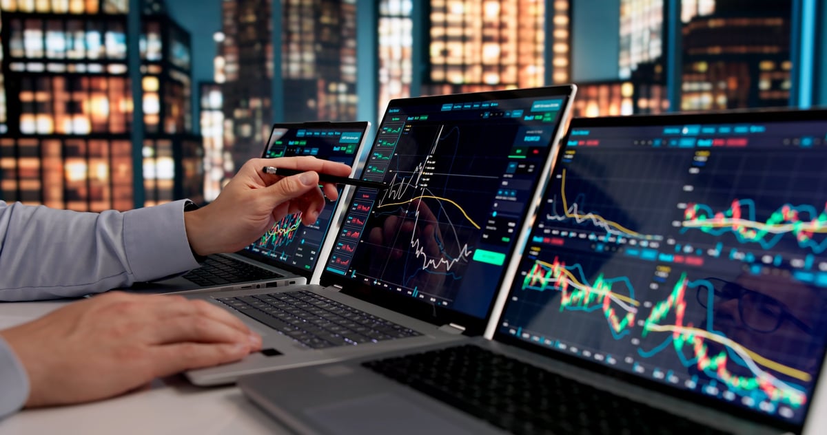 Stockbroker monitoring market trends on laptop, making strategic trades